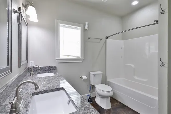 a bathroom with a granite countertop sink toilet and shower