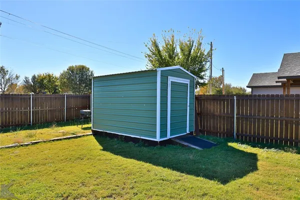 a view of a backyard with wooden fence