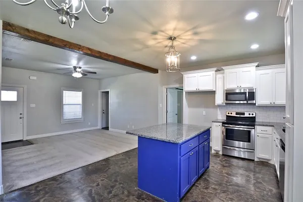 a kitchen with stainless steel appliances granite countertop a sink refrigerator and stove