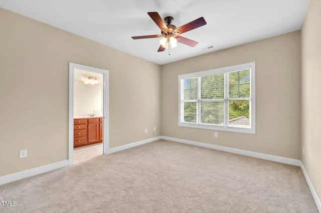an empty room with window and a ceiling fan