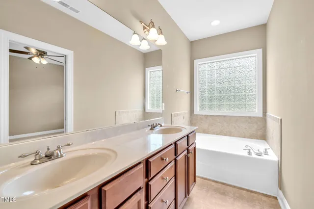 a bathroom with a tub sink and mirror