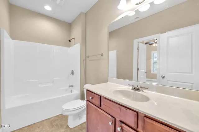 a bathroom with a sink a toilet a large mirror and shower