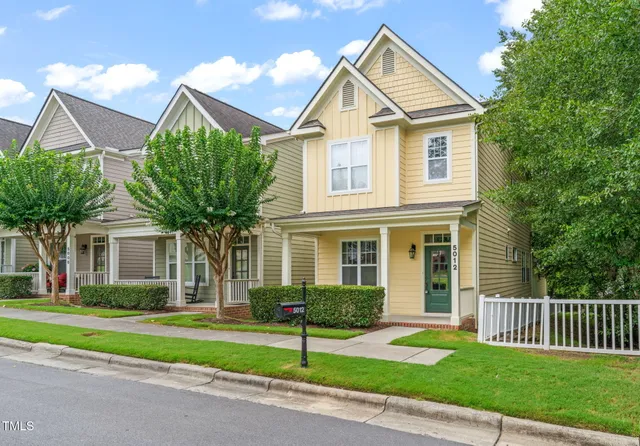 a front view of a house with a garden and plants