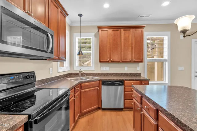 a kitchen with stainless steel appliances granite countertop a stove a sink and a microwave