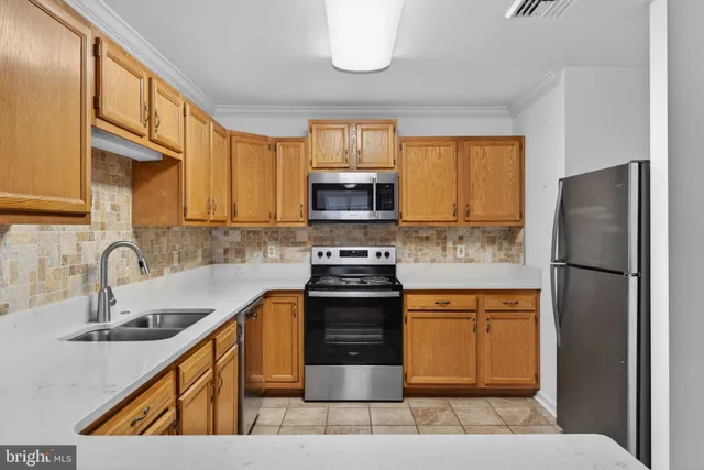 a kitchen with a sink a refrigerator and a stove