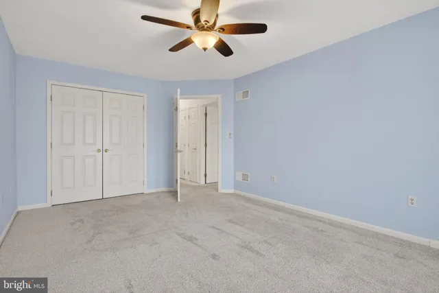 an empty room with chandelier fan
