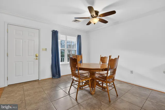 a view of a dining room with furniture and a ceiling fan