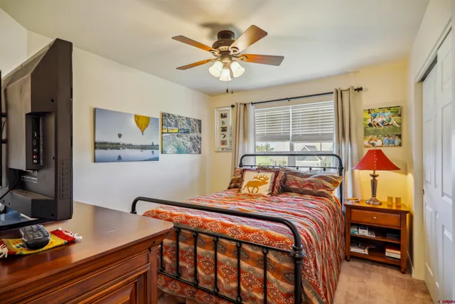 a bedroom with a bed and a flat tv screen on the dresser