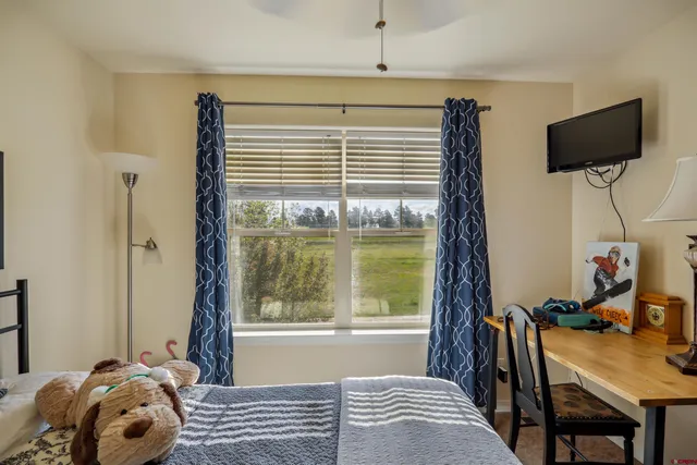 a view of a workspace with furniture and a window