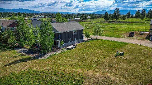 an aerial view of a house with yard and lake view