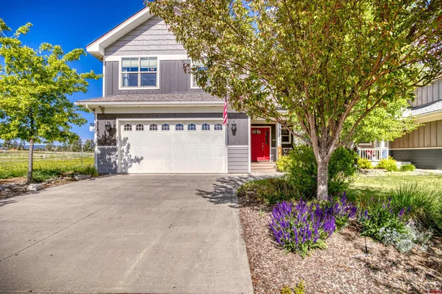 a front view of a house with a yard and a garage