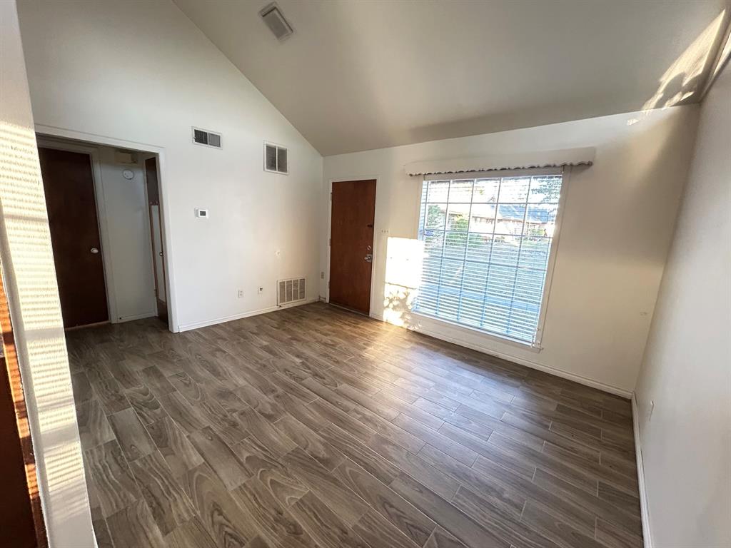 409 Royal Street, Unit 1 Athens, TX 75751 - Photo 4 of 14 an empty room with wooden floor and windows