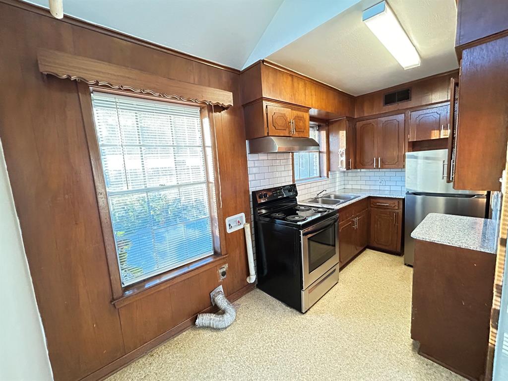 409 Royal Street, Unit 1 Athens, TX 75751 - Photo 5 of 14 a kitchen with stainless steel appliances granite countertop a stove a sink and a refrigerator