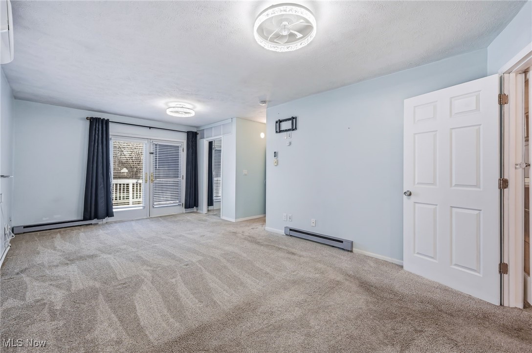 245 North Road Niles, OH 44446 - Photo 19 of 45 Unfurnished room with a baseboard heating unit, light colored carpet, a textured ceiling, and baseboard heating