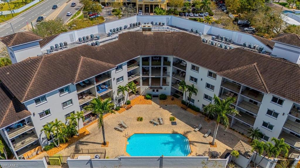 1100 Pine Ridge Road, Unit B106 Naples, FL 34108 - Photo 2 of 10 Drone / aerial view of a pool and apartment complex