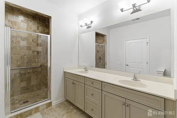 a bathroom with a shower sink and mirror