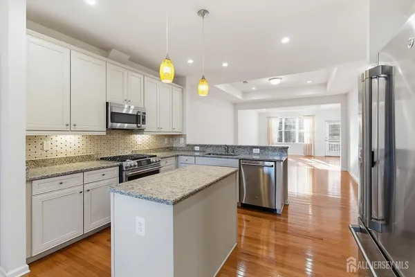 a kitchen with stainless steel appliances granite countertop a stove a sink and a refrigerator