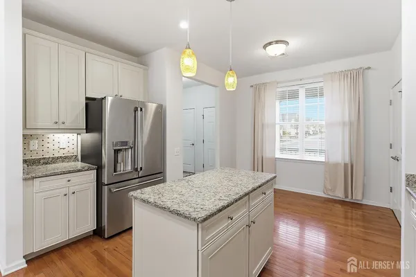 a kitchen with granite countertop a refrigerator and a sink
