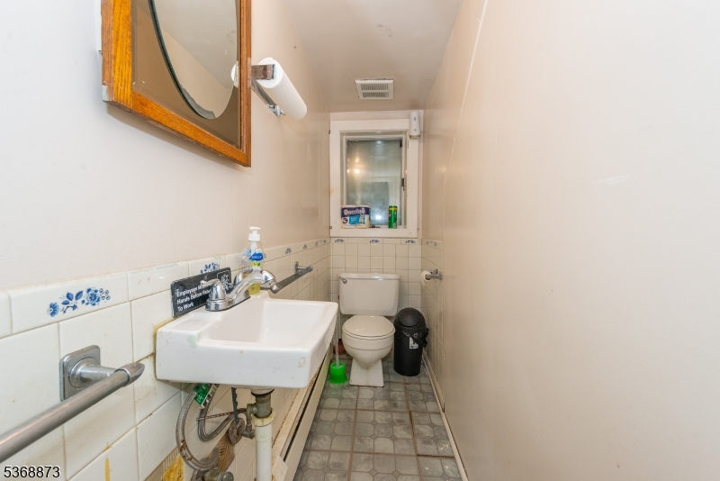609 Madison Avenue, Unit 2 Paterson, NJ 07514 - Photo 13 of 43 a bathroom with a sink a mirror and a toilet