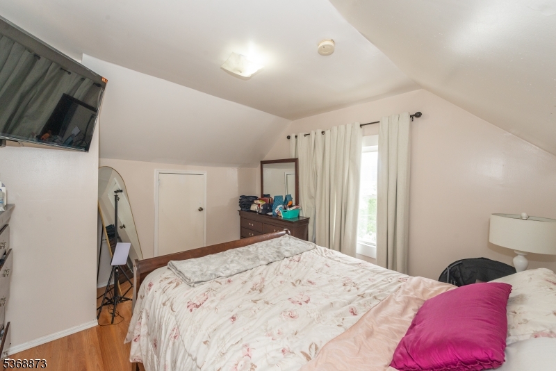 609 Madison Avenue, Unit 2 Paterson, NJ 07514 - Photo 31 of 43 a bedroom with a bed and a flat screen tv
