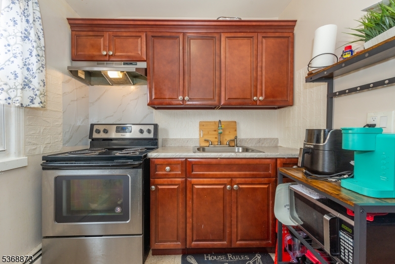 609 Madison Avenue, Unit 2 Paterson, NJ 07514 - Photo 40 of 43 a kitchen with stainless steel appliances granite countertop a stove and a microwave