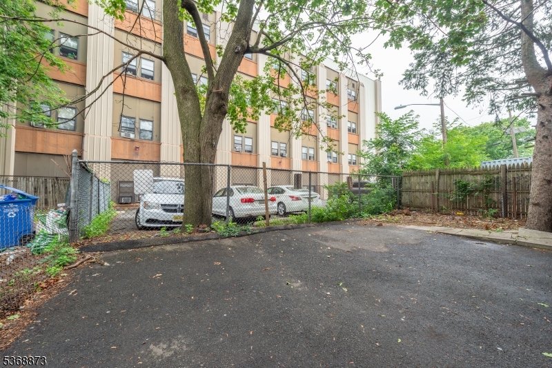609 Madison Avenue, Unit 2 Paterson, NJ 07514 - Photo 10 of 43 a view of a brick house with a large windows and a large tree