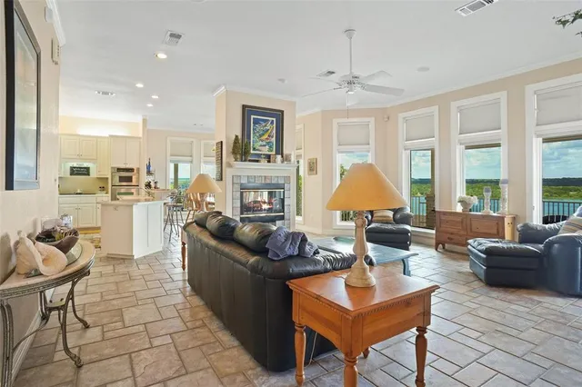 a living room with fireplace furniture and a large window