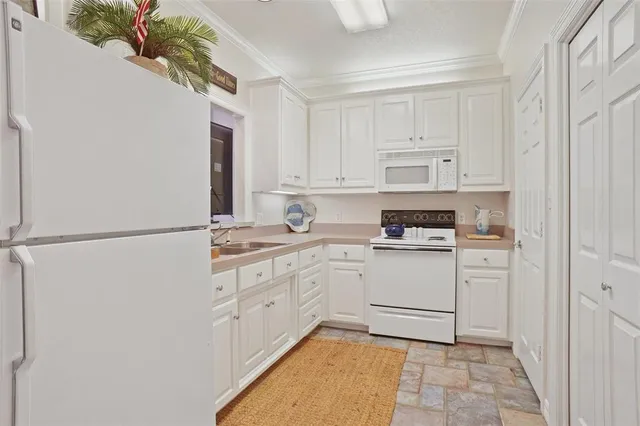 a kitchen with white cabinets and white appliances
