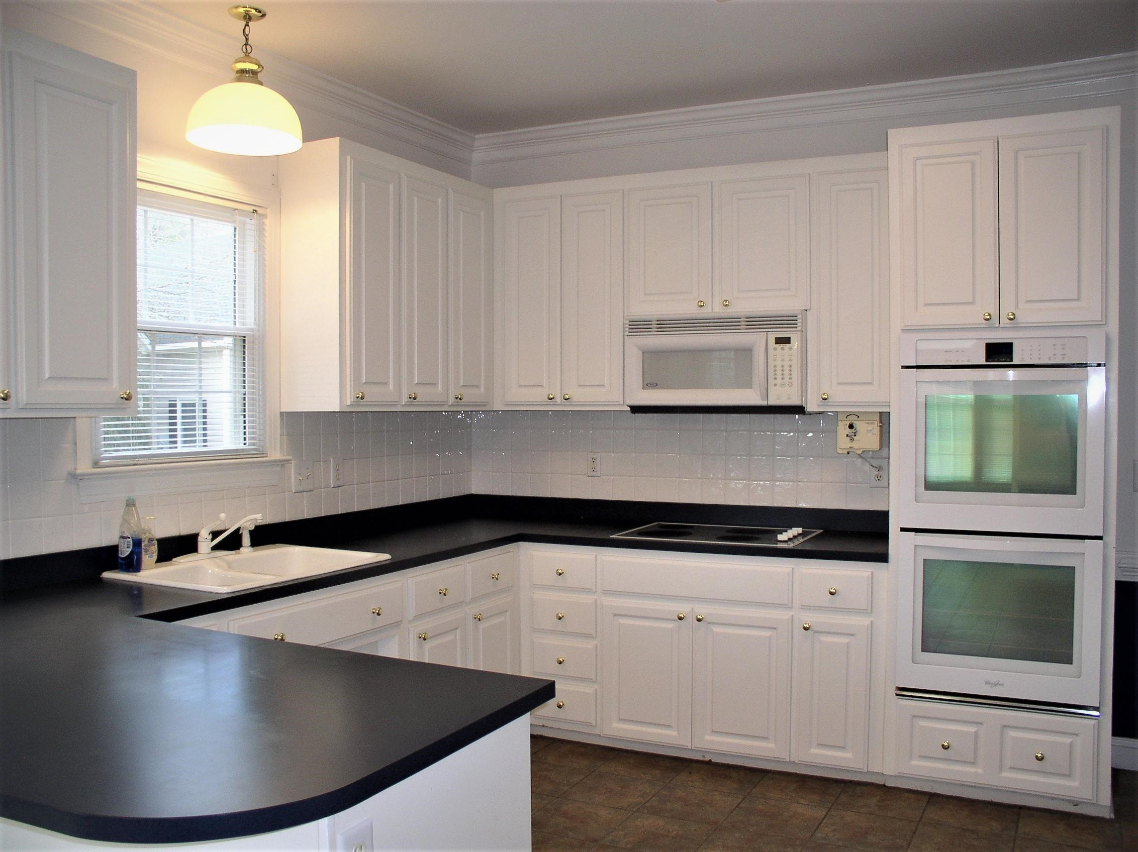 3516 Kapalua Way Raleigh, NC 27610 - Photo 3 of 42 a kitchen with granite countertop white cabinets and a stove