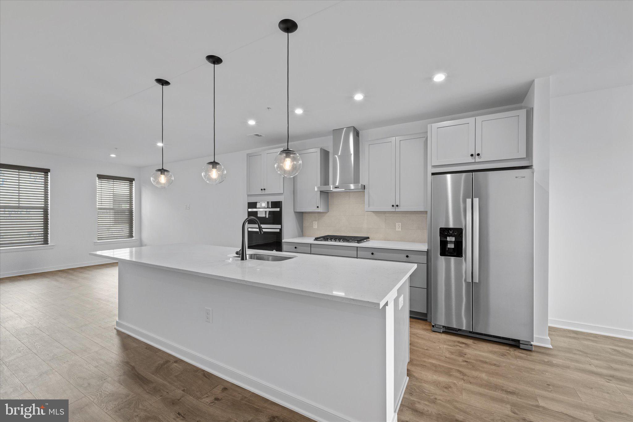 46207 Woodpecker Square Sterling, VA 20165 - Photo 4 of 37 a large kitchen with stainless steel appliances kitchen island a stove a refrigerator a sink and a oven