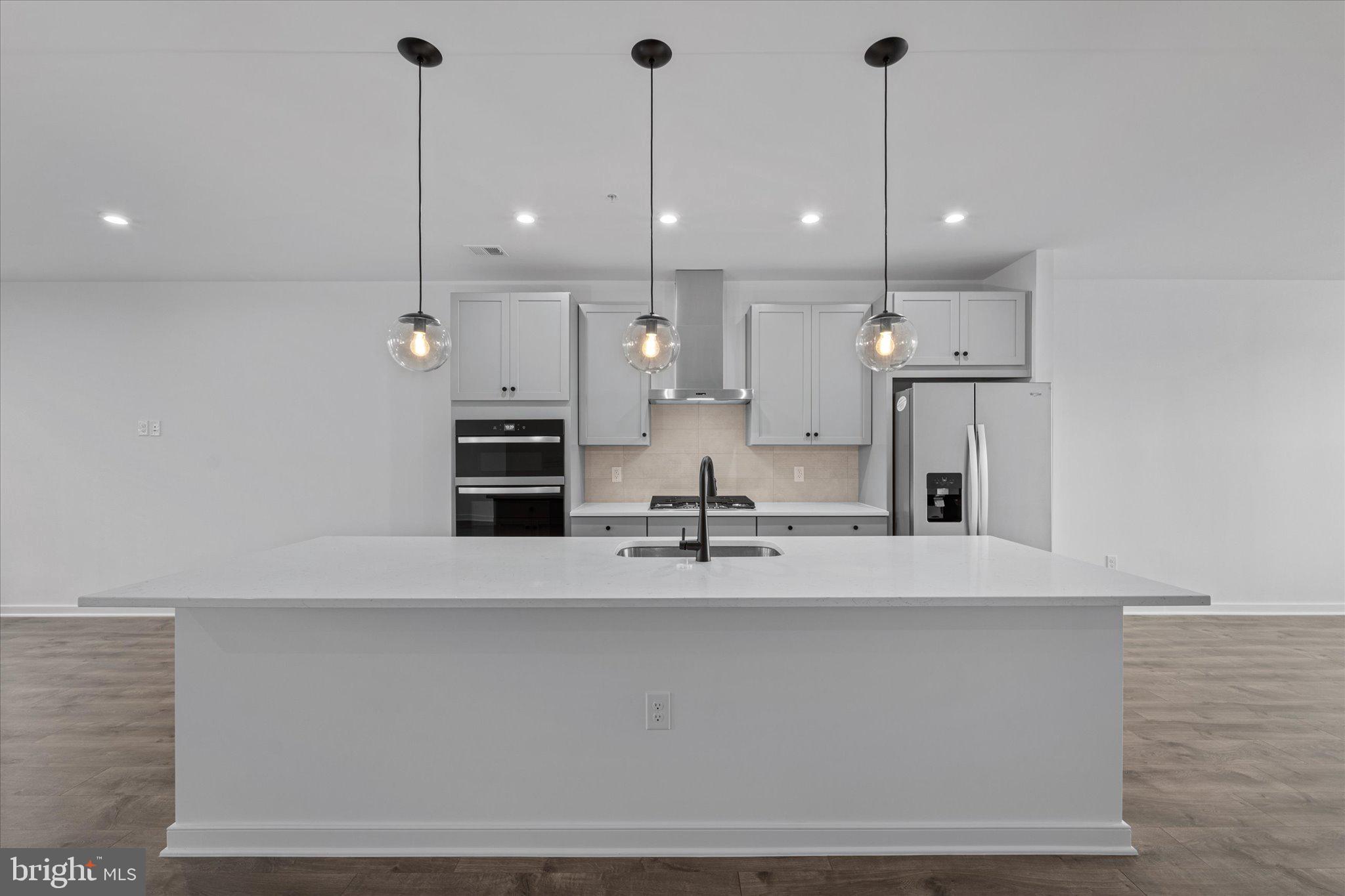 46207 Woodpecker Square Sterling, VA 20165 - Photo 5 of 37 a large kitchen with stainless steel appliances kitchen island a large island in the center