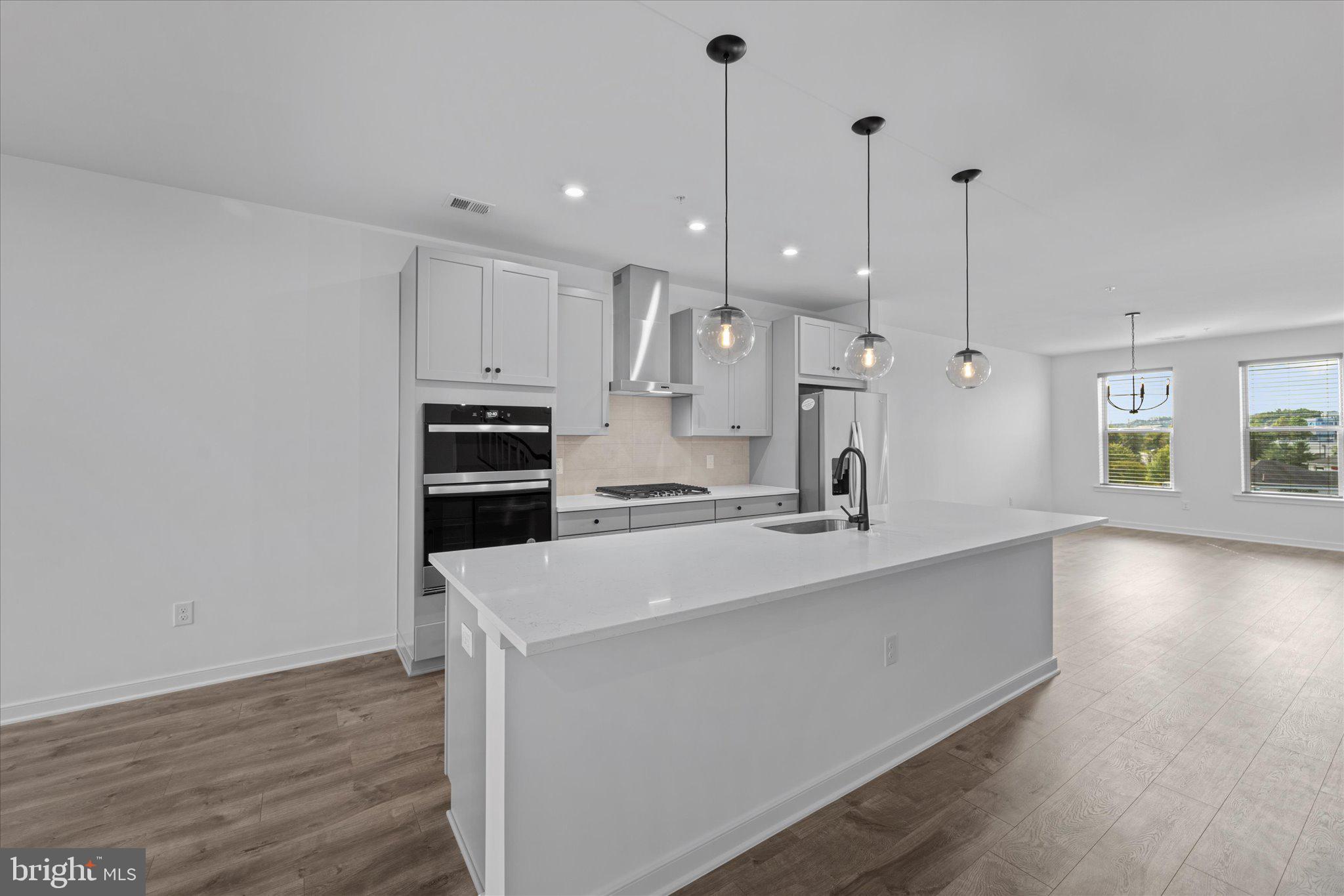 46207 Woodpecker Square Sterling, VA 20165 - Photo 6 of 37 a large kitchen with stainless steel appliances a large counter top a stove a sink and a floors