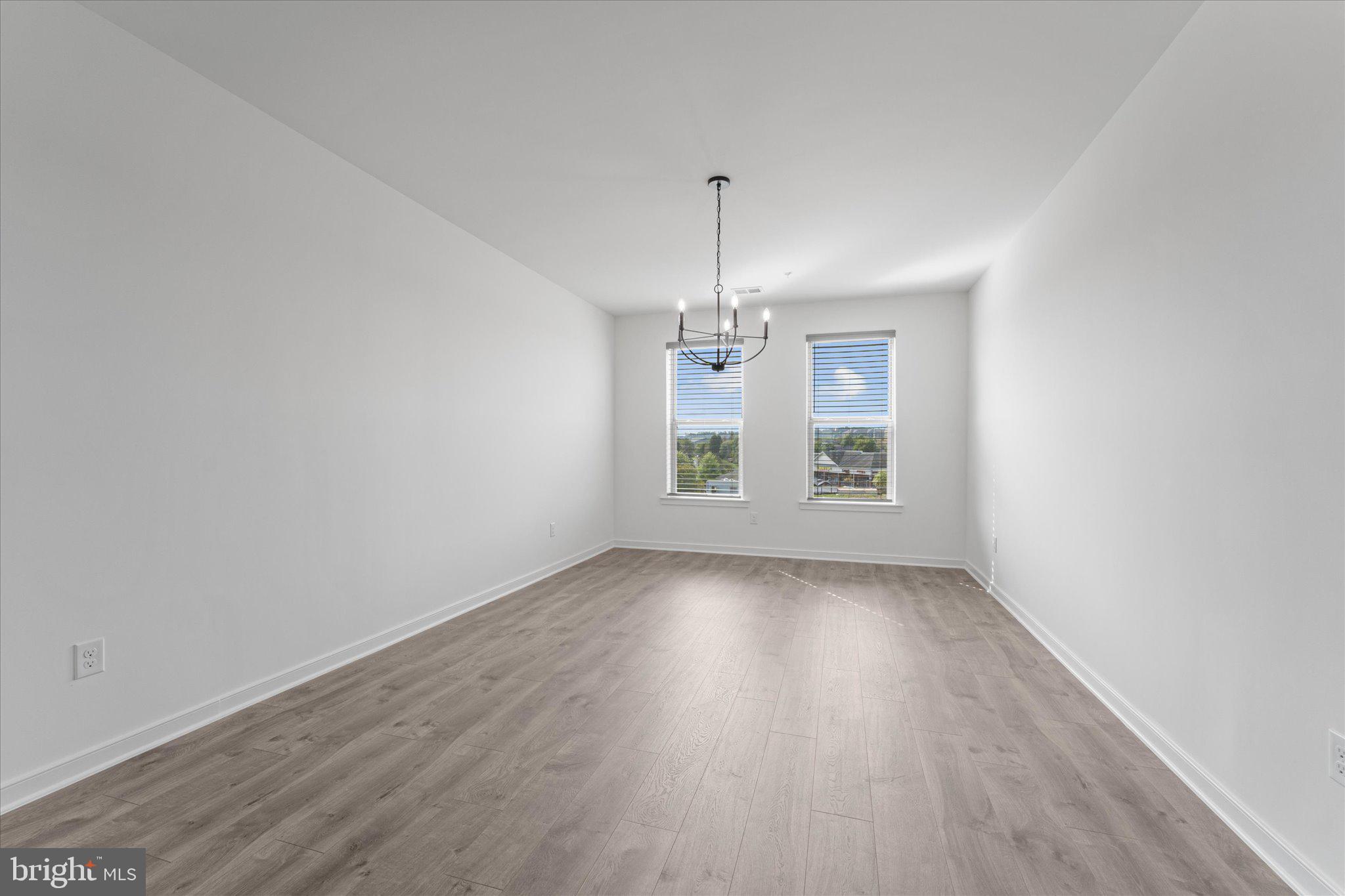 46207 Woodpecker Square Sterling, VA 20165 - Photo 9 of 37 an empty room with wooden floor chandelier and window