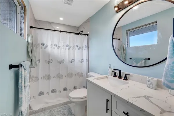 a bathroom with a sink a toilet and a mirror