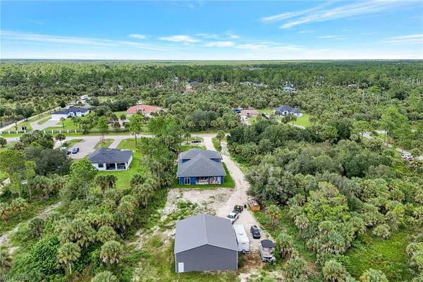 an aerial view of residential houses with outdoor space and trees