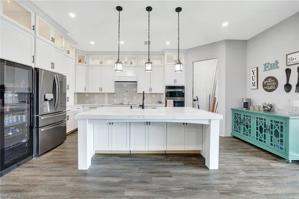 a kitchen with stainless steel appliances kitchen island granite countertop a refrigerator a sink and a oven