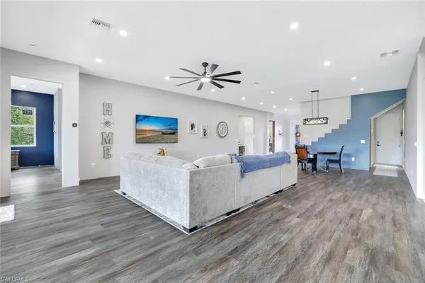 a living room with furniture and a wooden floor