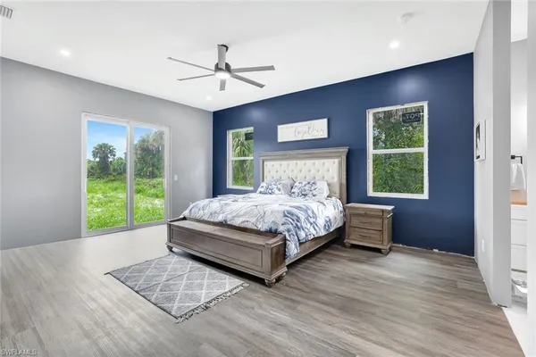 a bedroom with a bed and a large window