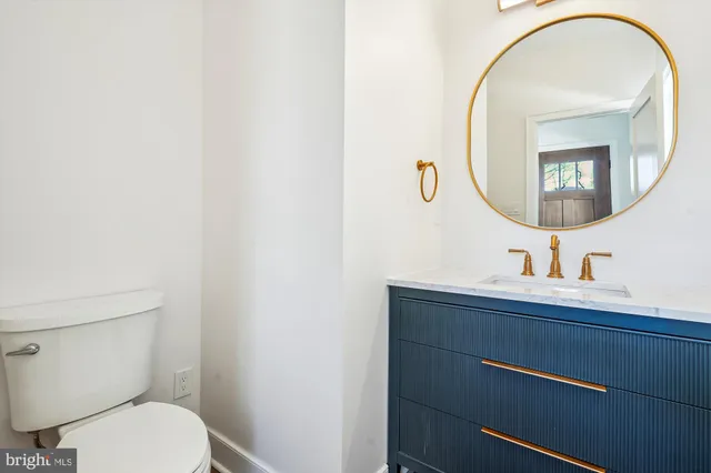 a spacious bathroom with a double vanity sink toilet and a mirror
