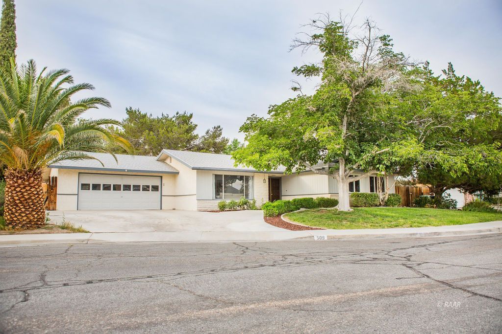 509 Las Posas Street Ridgecrest, CA 93555 - Photo 1 of 1 a front view of a house with a yard and trees
