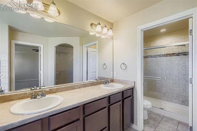 a bathroom with a sink double vanity granite toilet and shower