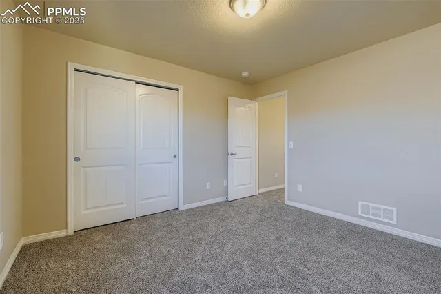 an empty room with windows and closet
