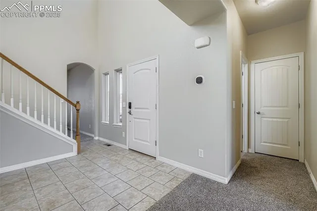 a view of a hallway with entryway and stairs