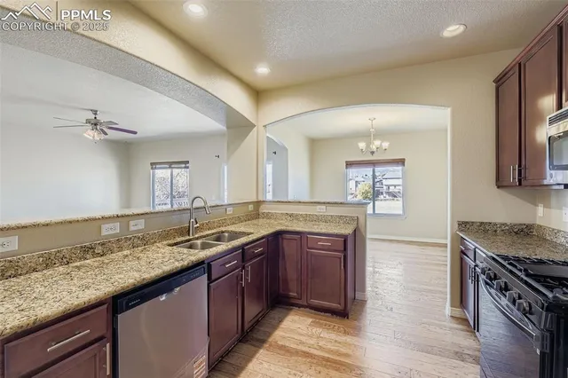 a kitchen with granite countertop stainless steel appliances and wooden cabinets