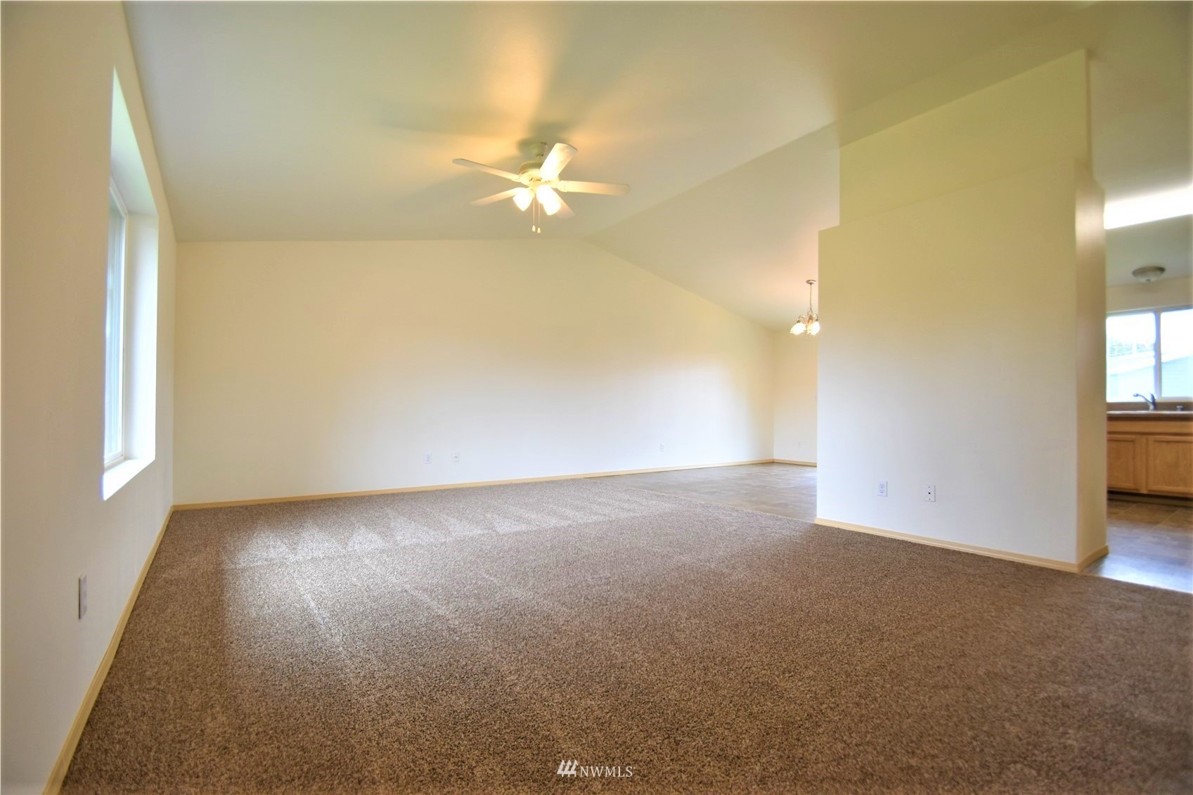 6346 198th Trail Southwest Rochester, WA 98579 - Photo 3 of 16 an empty room with a chandelier fan and windows