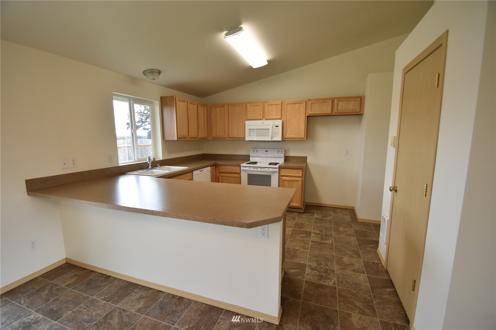 6346 198th Trail Southwest Rochester, WA 98579 - Photo 5 of 16 a kitchen with granite countertop a sink a stove and a refrigerator