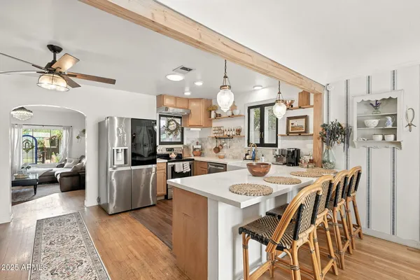 a dining room with stainless steel appliances kitchen island granite countertop a dining table and chairs
