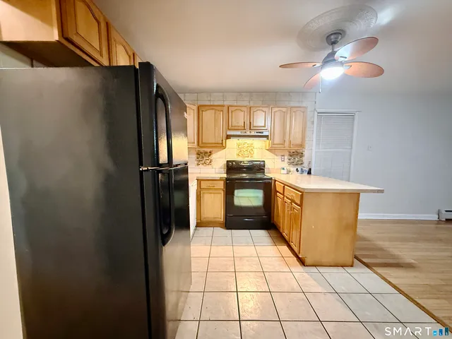 a kitchen with stainless steel appliances granite countertop a refrigerator a sink a stove a washer and dryer