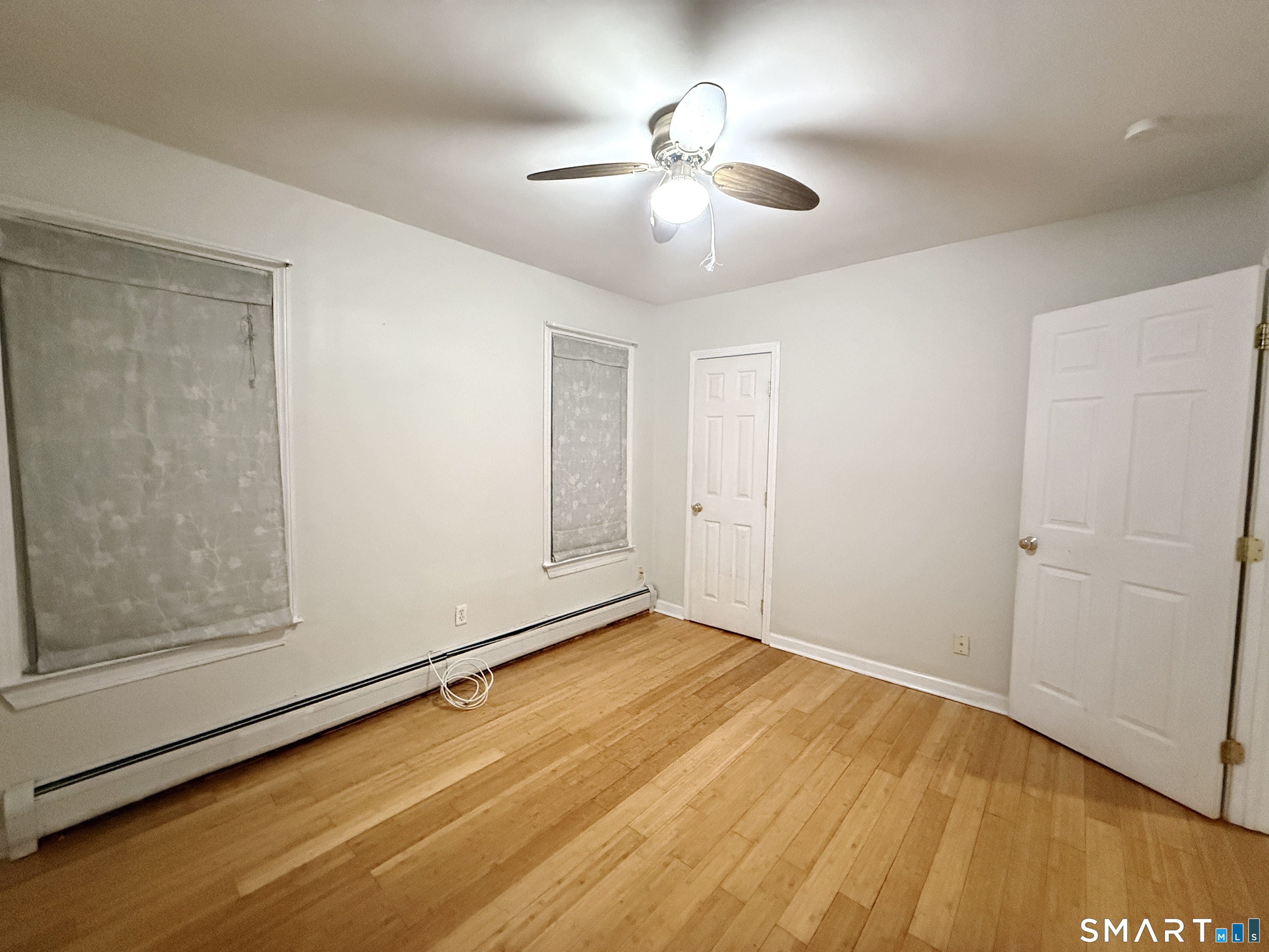 78 Lindley Street Bridgeport, CT 06604 - Photo 6 of 9 a view of an empty room with wooden floor and a ceiling fan
