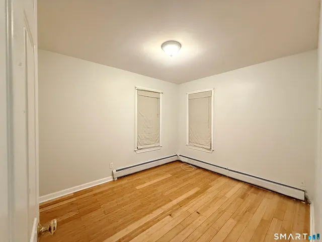 a view of empty room with wooden floor